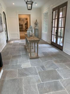 a large foyer with stone flooring and doors