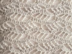 a close up view of a white knitted blanket