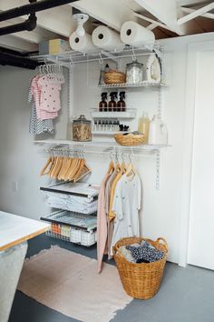 an organized closet with hanging clothes and baskets