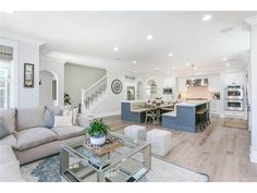 a living room filled with furniture next to a kitchen