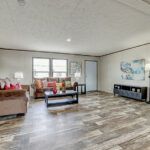 a living room filled with furniture and a flat screen tv on top of a hard wood floor