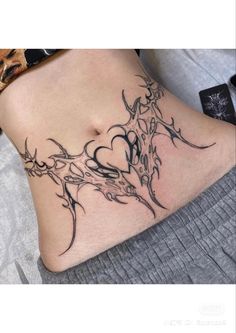 a woman's stomach with an artistic tattoo design on the side and bottom part