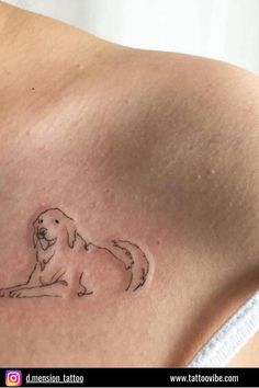 a small tattoo on the back of a woman's shoulder, with a dog