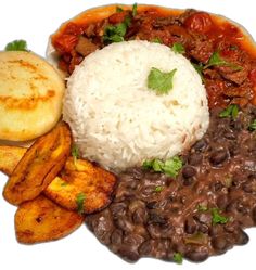 a white plate topped with beans and rice next to potato wedges on top of a table