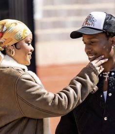 a man and woman standing next to each other on the street smiling at each other