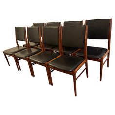 six chairs with black leather seats are lined up