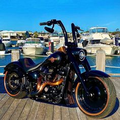 a black motorcycle parked on top of a wooden dock