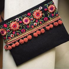 a black purse with flowers and tassels on it