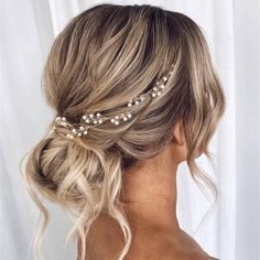 a woman with blonde hair wearing a gold headband and pearls in it's hair