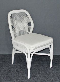 a white wicker chair against a gray wall