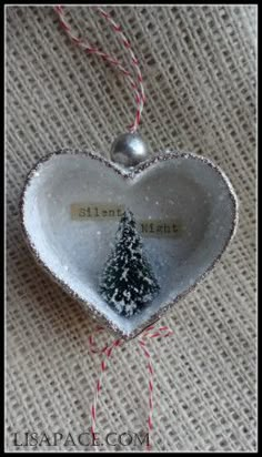 an ornament shaped like a heart with a christmas tree on it