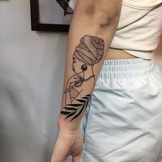 a woman's arm with a black and white tattoo design on the left forearm