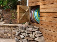 a wooden building with a colorful striped surfboard sticking out of it's door