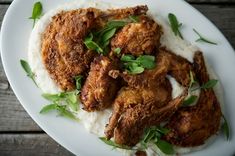 fried chicken and mashed potatoes on a white plate with garnishes around the edges