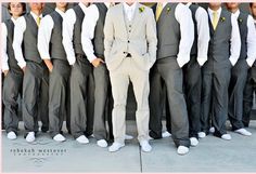 a man standing in front of a group of men wearing suits and ties with their arms around each other