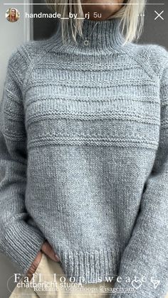 a woman is wearing a gray sweater and tan pants with her hands in her pockets