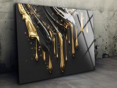 a black and gold painting on the wall with some dripping paint onto it's surface