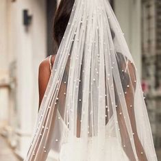 the back of a bride's veil with pearls on it