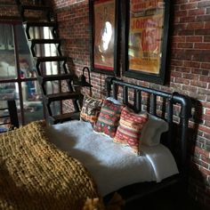 a bed in a room with brick walls and two framed pictures on the wall above it