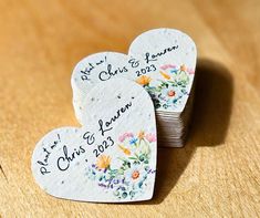 two heart shaped coasters with wedding date written on them sitting next to each other