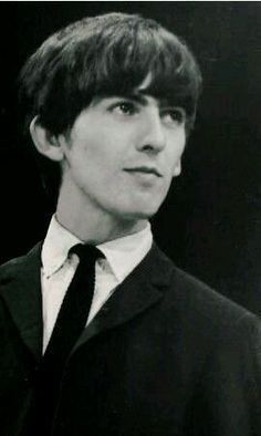 black and white photograph of young man in suit and tie looking off to the side