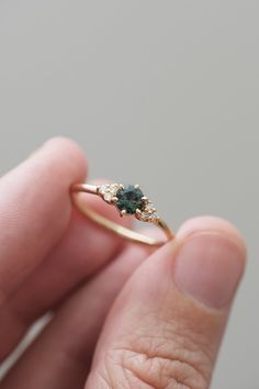 a person holding a ring with two stones on it