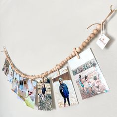 several pictures hanging on a string with clothes pins attached to them and some wood beads