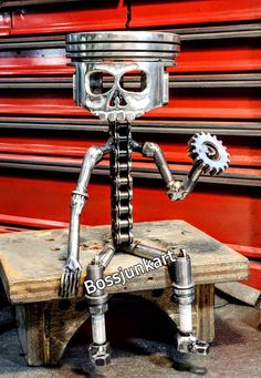 a metal robot sitting on top of a wooden bench