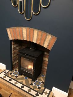 a fireplace with a wood burning stove in the corner and mirrors on the wall above it