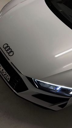 the front end of an audi car with its lights on