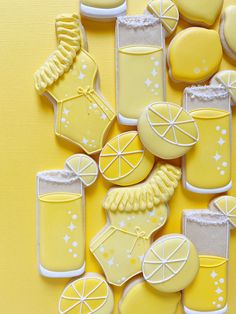 decorated cookies with lemonade and cocktails on yellow background