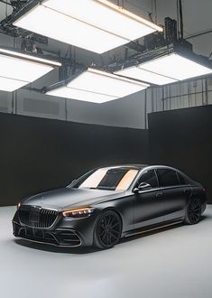 the new mercedes s - class sedan is shown in an empty room with lights overhead