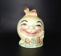 a ceramic figurine with a smiling face on it's head