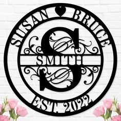 a metal sign that says susan brinde and smith established in black on a white brick wall