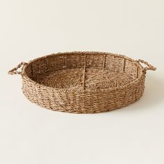 a woven basket with handles on a white background