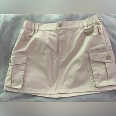 Khaki Cargo Skirt Never Worn Size Large Cream Cargo Skirt, Beige High Waist Mini Skirt With Pockets, Beige High-waist Mini Skirt With Pockets, Casual Khaki Mini Skirt, Casual Beige Mini Skirt With Pockets, Casual Khaki Mini Skort, Casual Beige Skirt With Pockets, Casual Beige Mini Skirt, Casual Amazon Bottoms With Pockets