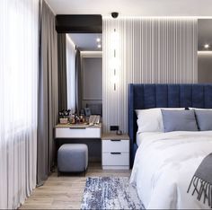 a bedroom with a blue headboard and white bedding is pictured in this image