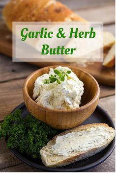 garlic and herb butter in a wooden bowl on a black plate with bread next to it