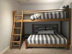 a bunk bed sitting in the corner of a room next to a ladder and pillows