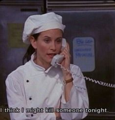 a woman talking on a phone while wearing a chef's hat and holding a telephone to her ear