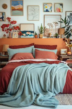 a bed with red and blue comforters in a bedroom next to pictures on the wall