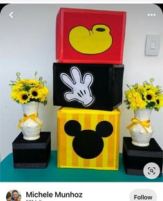 mickey mouse boxes are stacked on top of each other with sunflowers in them