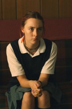 a woman sitting on top of a couch in front of a red and green wall