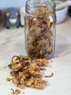 a glass jar filled with granola sitting on top of a counter