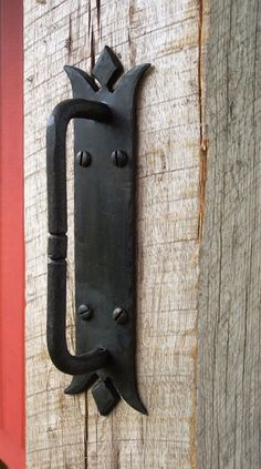 an old black door handle on a wooden door