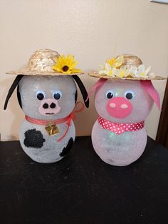 two stuffed animals wearing hats on top of a table