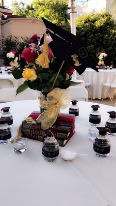 a table topped with books and vases filled with flowers