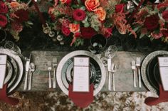 the table is set with silverware and red napkins