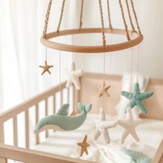 a baby crib with sea animals and stars hanging from it