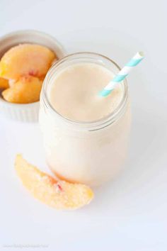 a smoothie in a mason jar with a blue and white striped straw next to it